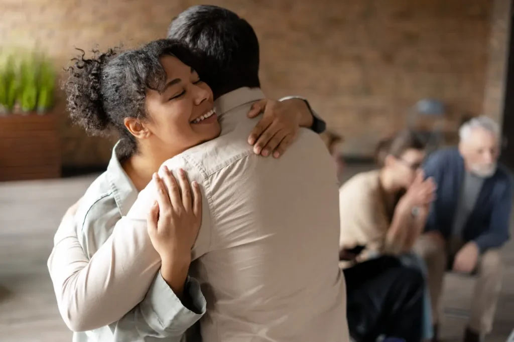 The Grove Recovery | happy african american woman hugging coach at ther 2025 06 26 20 41 31 utc Large